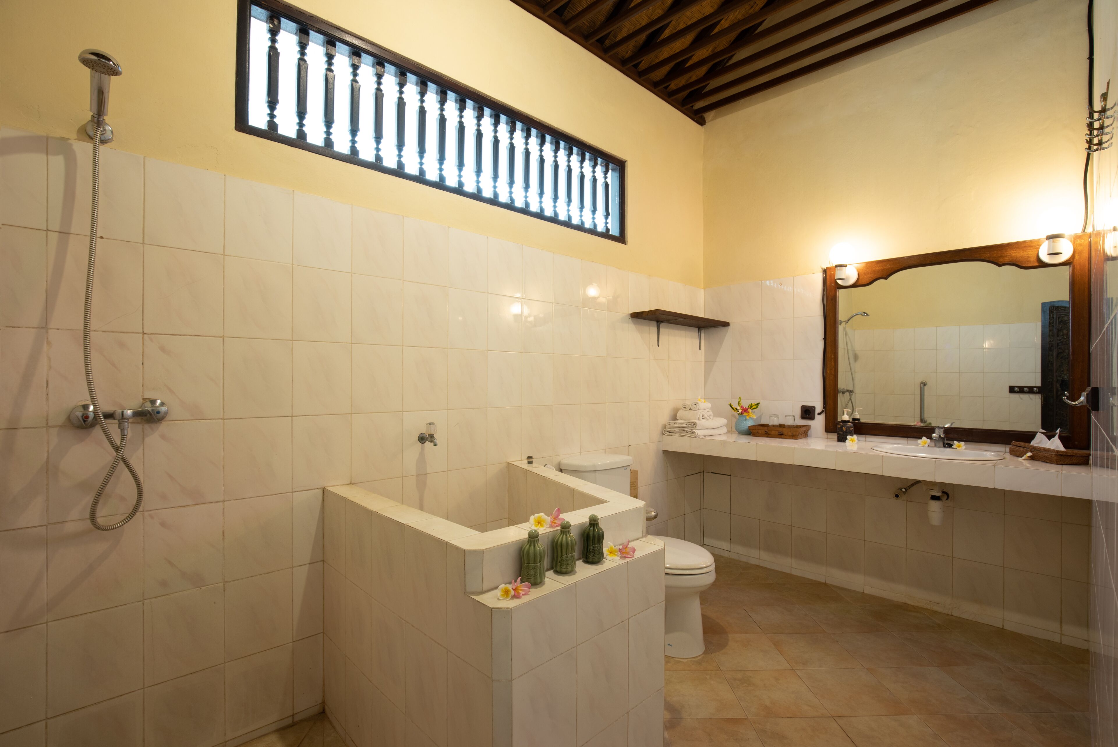 Een badkamer met een douche, toilet, wastafel en een spiegel met verlichting.