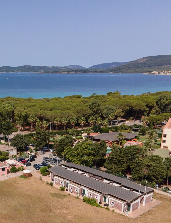 Una zona costera con una hilera de edificios, un estacionamiento y vistas al mar.