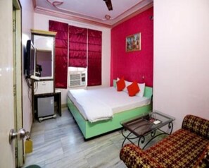 A room with a bed, a television, a small table, and a sofa. - Hotel Shri Ram International (Varanasi)