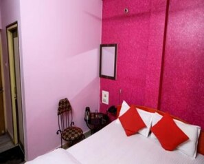 A room with a bed, a chair, and a small table. - Hotel Shri Ram International (Varanasi)
