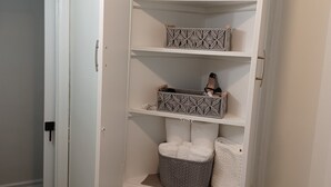 A white closet with shelves, a hanging shoe organizer, and a tissue box.
