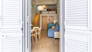 An open door leading to a dining area with a table and chairs, a staircase, and a blue sofa in the background. - GuestHost - Cozy 50 sqm apartment, able to accommodate up to 3 people, located on the ground floor of a building facing the beach. The property is located in Giardini Naxos, a wonderful seaside area 1.8 km from the pretty village of Schisò and just 2 km (Giardini Naxos)