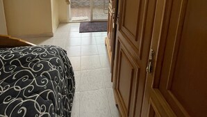 A hotel room with a bed, wardrobe, and a sliding glass door leading to a balcony. - Grand Duplexe Mer et Piscine in Tangier (طنجة)