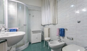 A bathroom with two sinks, a bidet, a toilet, and a shower with a glass door. - Casa Vacanza Clara (Gallipoli)