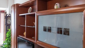 Eine Holzvitrine mit Glastüren, Regalen und Dekorationselementen.