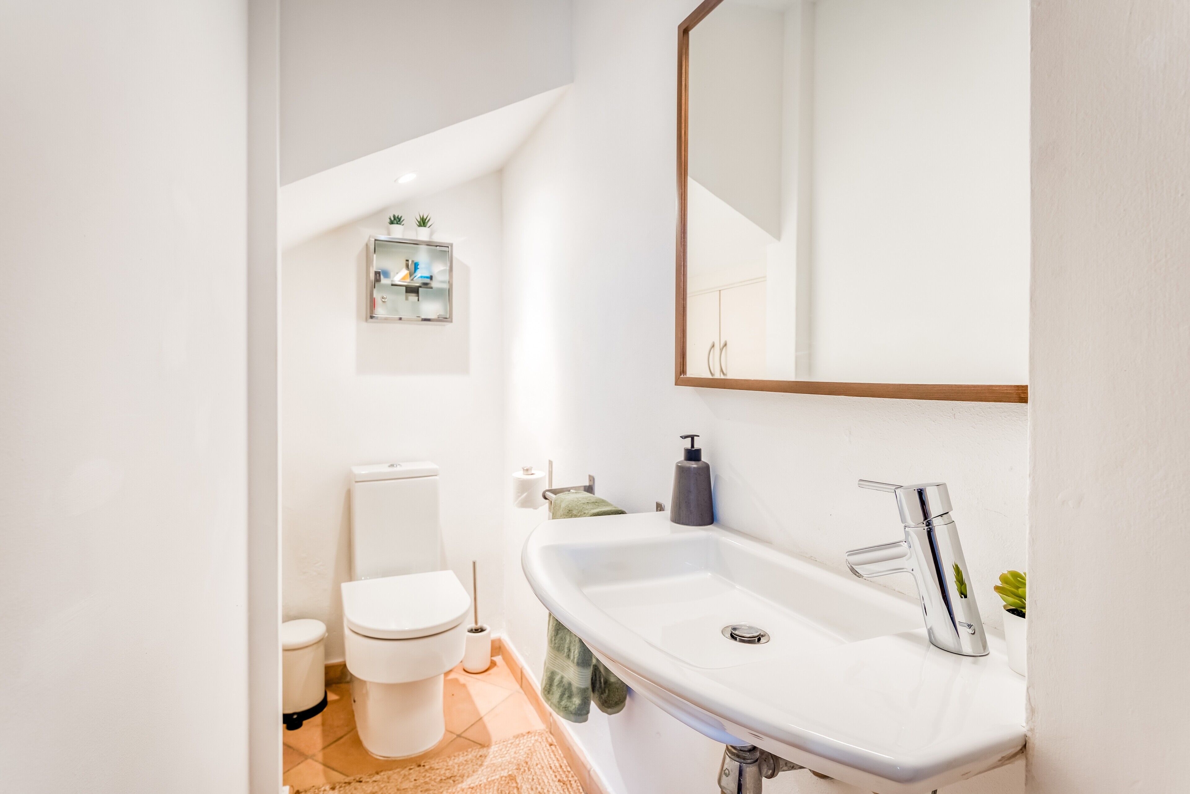Une salle de bain moderne avec des toilettes, un lavabo et un miroir.