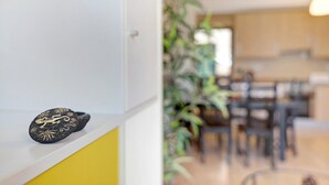 Un interno moderno con zona pranzo, cucina e una pianta.