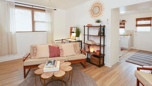Ein gemütliches Wohnzimmer mit Sofa, Couchtisch und Bücherregal.