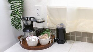 Una encimera de cocina con una cafetera, una licuadora y dos tazones de ingredientes.
