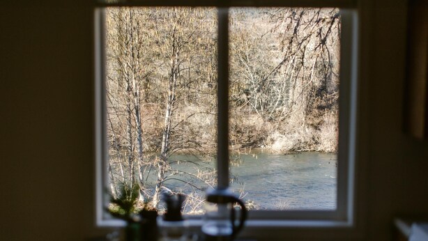 Una ventana con vista a un río y árboles.