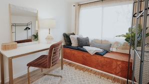 A modern bedroom with a wooden desk, a comfortable chair, a bed with a view, and a large window. - Located in a scenic area perfect for travelers along I-5. You are right by the Rogue River, offering stunning views and tranquility, yet conveniently positioned for easy travel access. (Gold Hill)