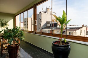 Enjoy the view from this balcony with a clear view of the surrounding buildings and lush greenery.