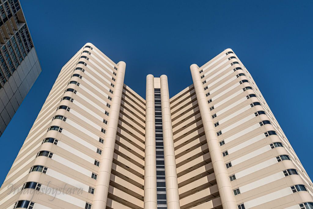 A high-rise building with a central core and multiple balconies.