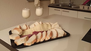 Cozinha com bancada exibindo uma tábua de queijos e dois copos de leite.