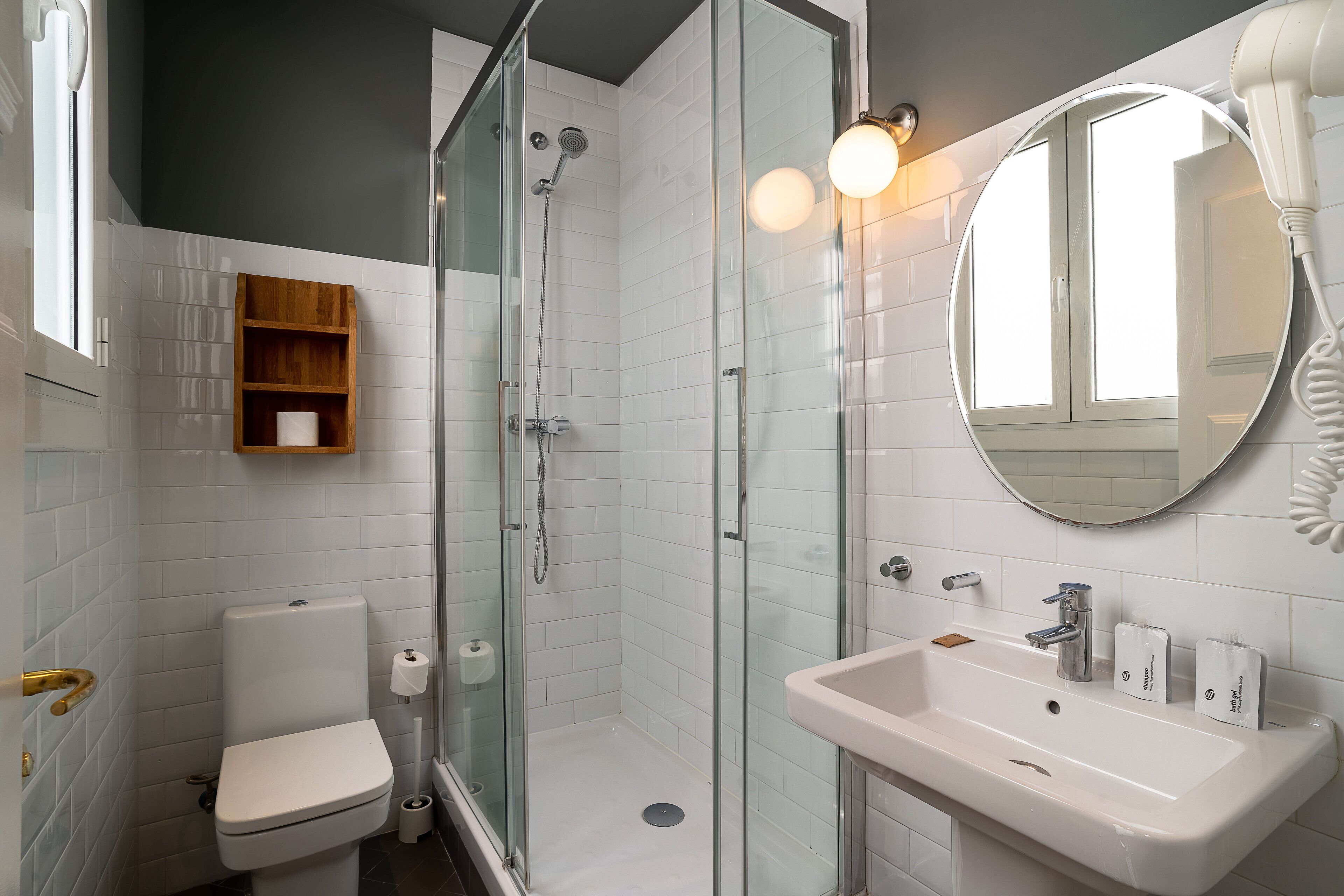 Een moderne badkamer met toilet, douche en wastafel.