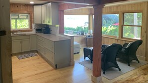 Una cocina amplia con armarios de madera, una isla integrada y grandes ventanales con vistas al exterior.