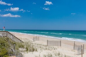 A beach with a wooden walkway, a flag, and ocean waves. - 2 Britt Buoys - Oceanfront 4BR duplex, (Surf City)