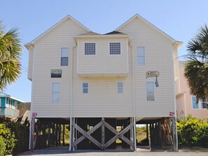 A two-story building with a gabled roof, a front garage, and a small porch area.