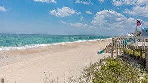 A beach with a wooden walkway, a lifeguard tower, and an American flag. - 2 Britt Buoys - Oceanfront 4BR duplex, (Surf City)