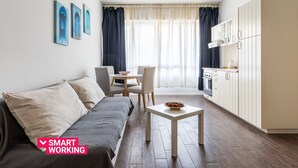 Un salon moderne comprenant un canapé, une table à manger et un coin cuisine.