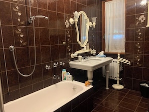 Tina con regadera, secadora de cabello, bidet, papel de baño