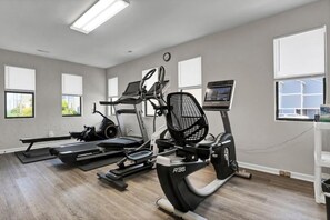 A gym with treadmills, an elliptical, and a stationary bike. - Sun And Surf - Top Floor 2 BR Surf Condo - Community Pool (Surf City)