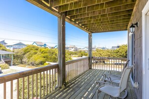 A wooden porch with a view of houses and vegetation. - Borders The Beach - 5BR Oceanfront Home with Amazing Views! (Surf City)
