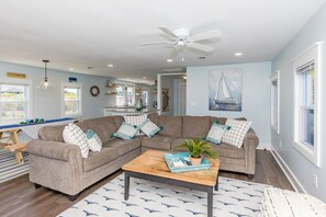 A living room with a sectional sofa, a coffee table, and a ceiling fan. - Shoreside Cottage - Classic 2 BR Beauty - Amazing Views from Covered Porch! Dog (Surf City)