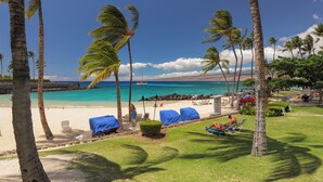 A beach view with palm trees, a sandy beach, and a clear blue sky. - Mauna Lani Townhome w/ Free Auberge Fitness Center Access (Kamuela)