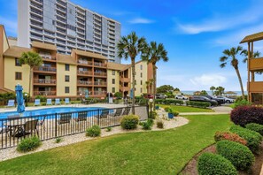 A hotel with a swimming pool, multiple balconies, and a view of the ocean.