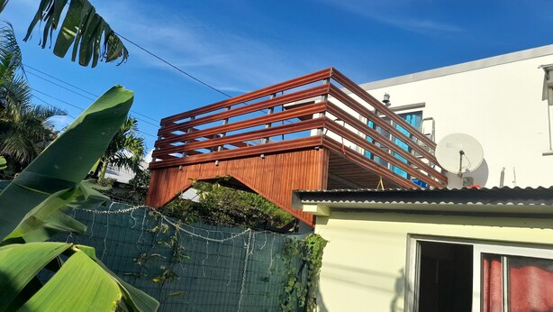 Ein modernes Gebäude mit einer Holzbrückenstruktur, einer Satellitenschüssel und einer weißen Fassade.