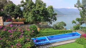 Una piscina con vistas a un lago y montañas.