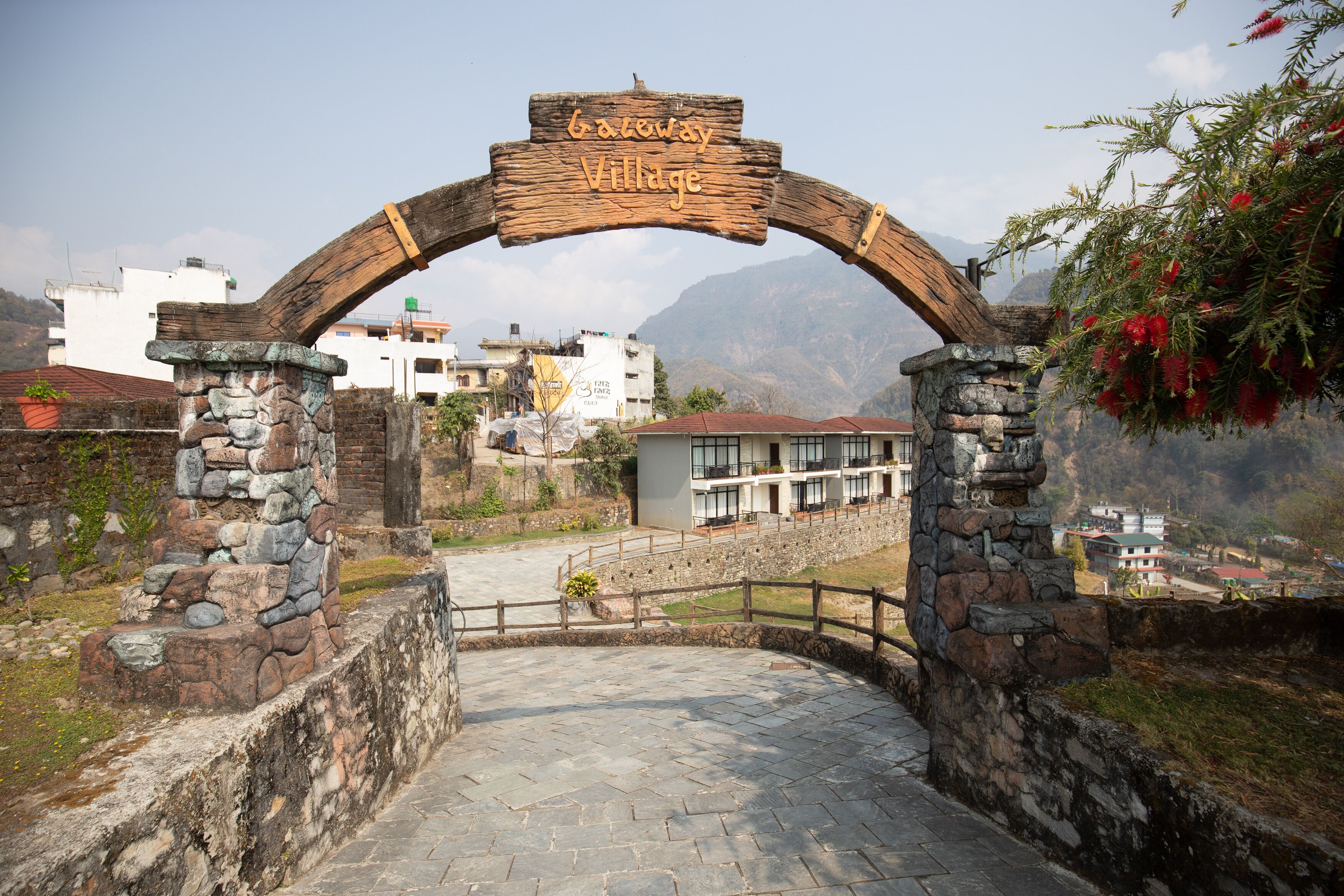An entrance archway with a sign reading "Gateway Village" leading to a stone pathway.