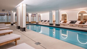 A modern indoor pool area with lounge chairs and a clear pool. - Radisson Blu Grand Hotel & Spa, Malo-Les-Bains (Dunkirk)