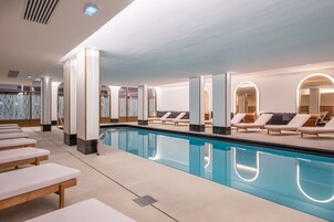 Una piscina techada, sillones reclinables de piscina