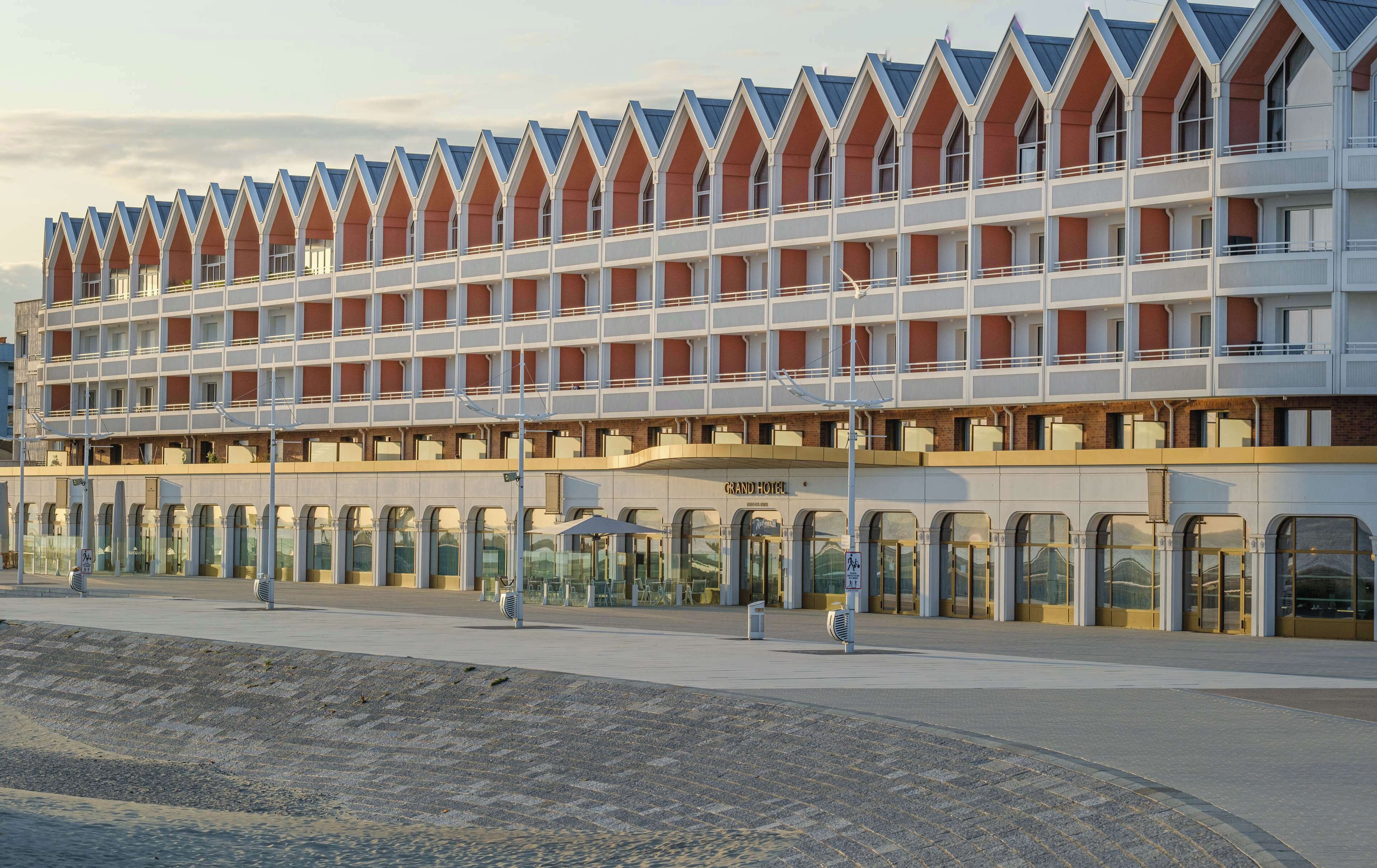 Un hôtel moderne doté d’une architecture originale, caractérisée par une série de bâtiments aux couleurs rouge et blanche.