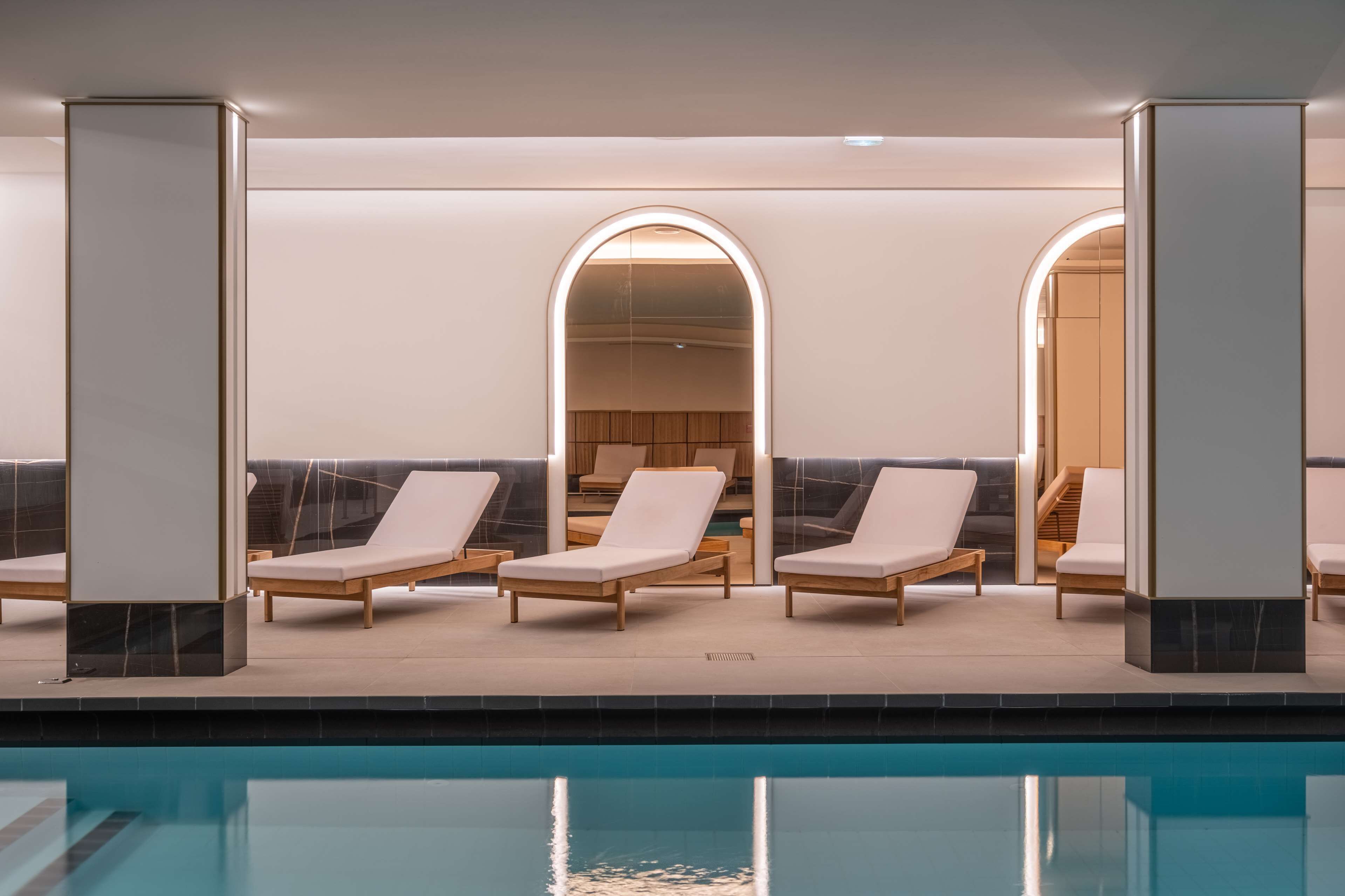 A poolside area with lounge chairs and a view of the pool.