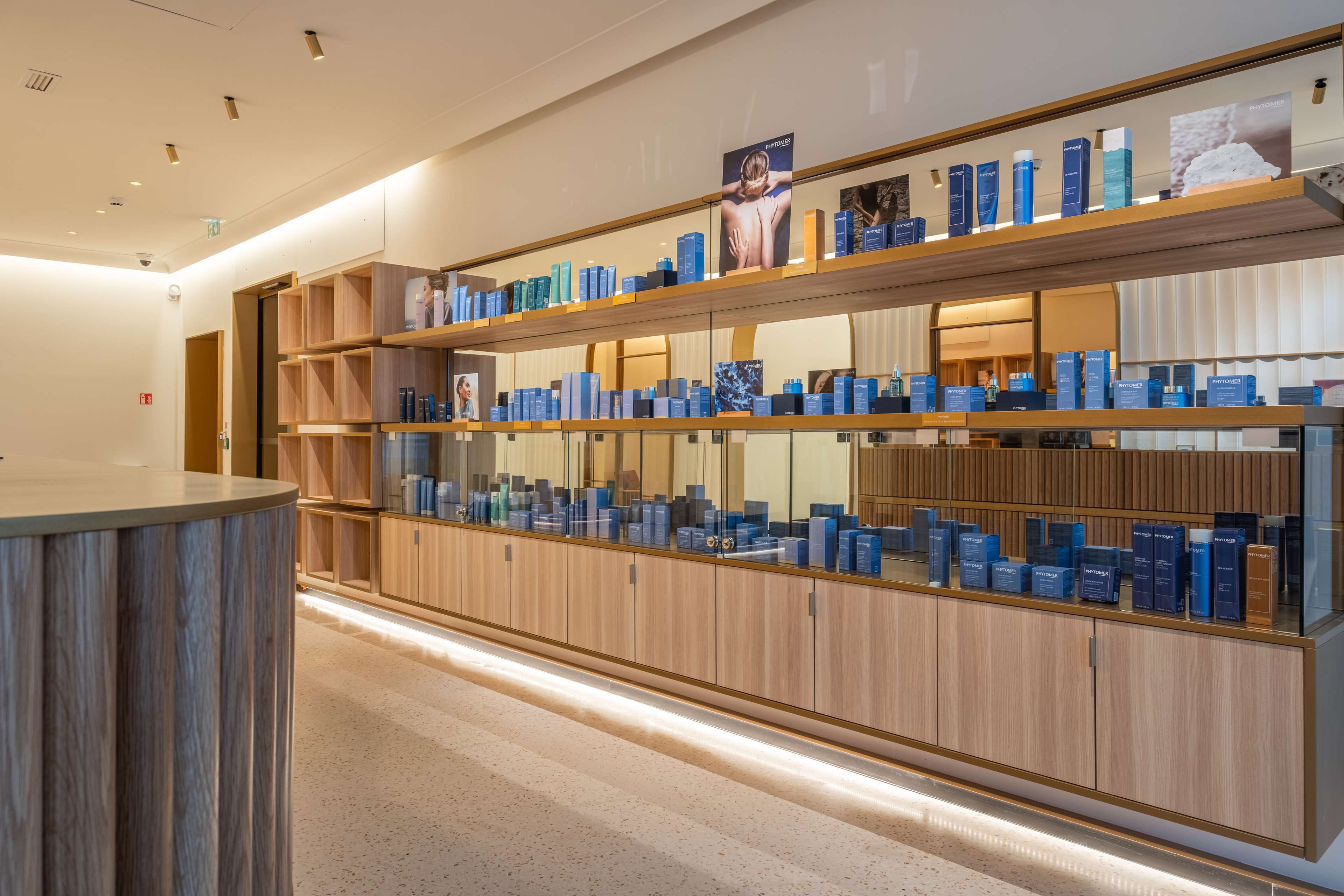 Un espace de vente moderne, doté d’étagères en bois où sont exposés divers produits.