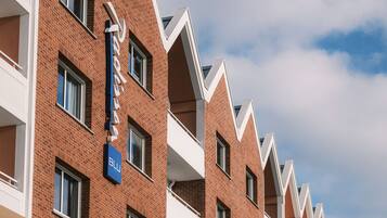 A row of red brick buildings with balconies and a sign that reads "Blu".