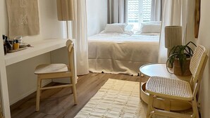 A compact bedroom with a bed, a desk, and a chair. - Milk and Cookies (Venlo)