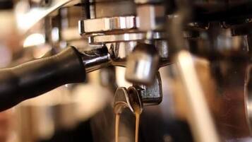 Een koffieapparaat schenkt espresso in een kopje.