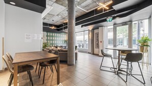 A modern office space with a large meeting table, comfortable seating, and large windows offering views of the street. - The Caïman Complex, 608 + parking (Québec City)