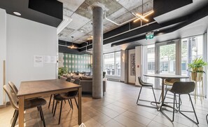 A modern office space with a large meeting table, comfortable seating, and large windows offering views of the street. - The Caïman Complex, 608 + parking (Québec City)