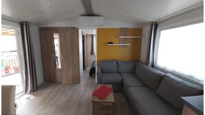 En modern inredning med en grå soffa, ett träbord och en gul accentvägg.