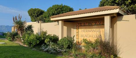 A building with a sign reading "Hermandus Beach Club".