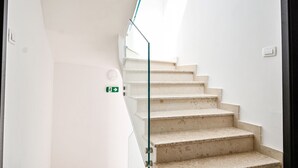 A staircase with a glass railing leading to a landing. - Modern Apartment with balcony and sea view (Milcetici)