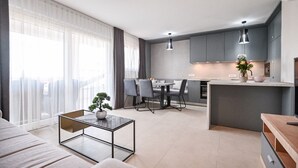 A modern apartment with a dining area, kitchen, and living room. - Modern Apartment with balcony and sea view (Milcetici)