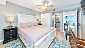 A bedroom with a bed, nightstands, a ceiling fan, and a view of the balcony. - Stunning Oceanfront Views w/Pool & Beach Access (Gulf Shores)