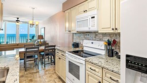 A kitchen with a large island, granite countertops, and a view of the ocean. - Stunning Oceanfront Views w/Pool & Beach Access (Gulf Shores)