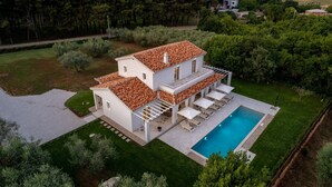 A two-story house with a swimming pool, surrounded by greenery and trees. - Lovely Villa Oliveti with a swimming pool (Frata)
